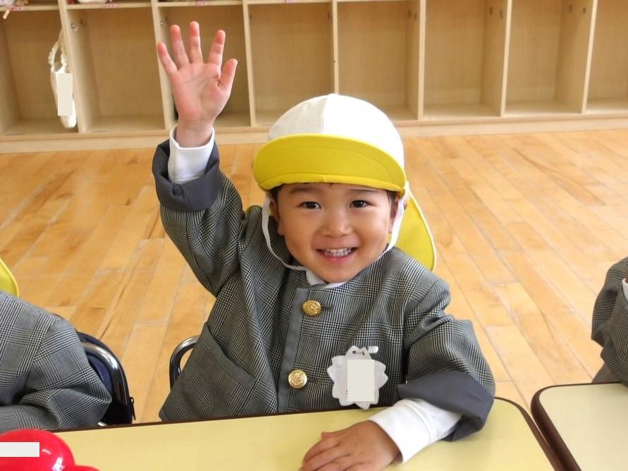 席で手を挙げている子ども