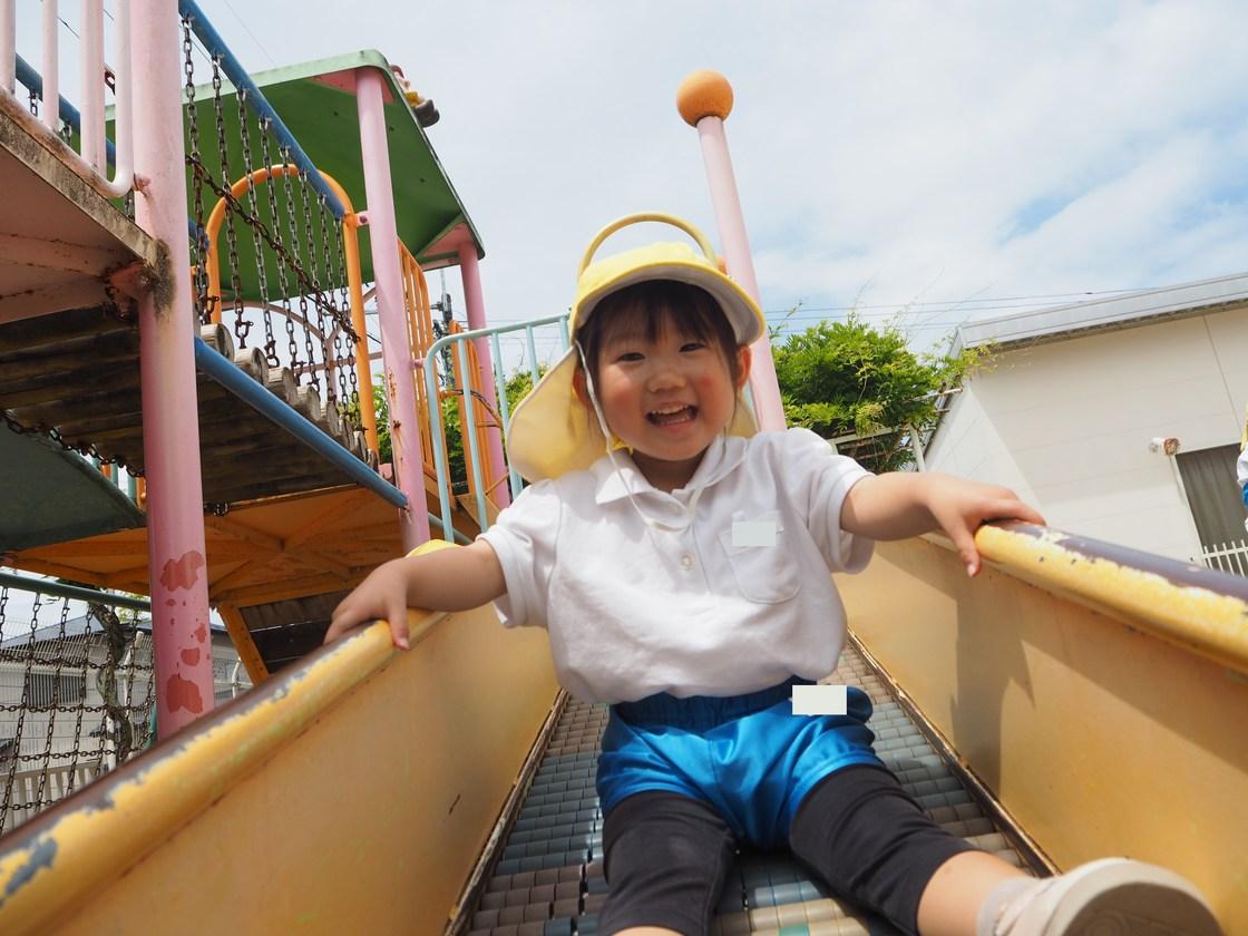 園庭のすべり台で遊ぶ子ども